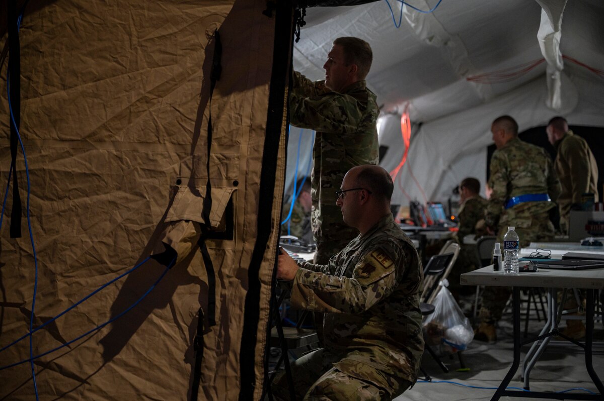 Pictured are people working inside of a tent.