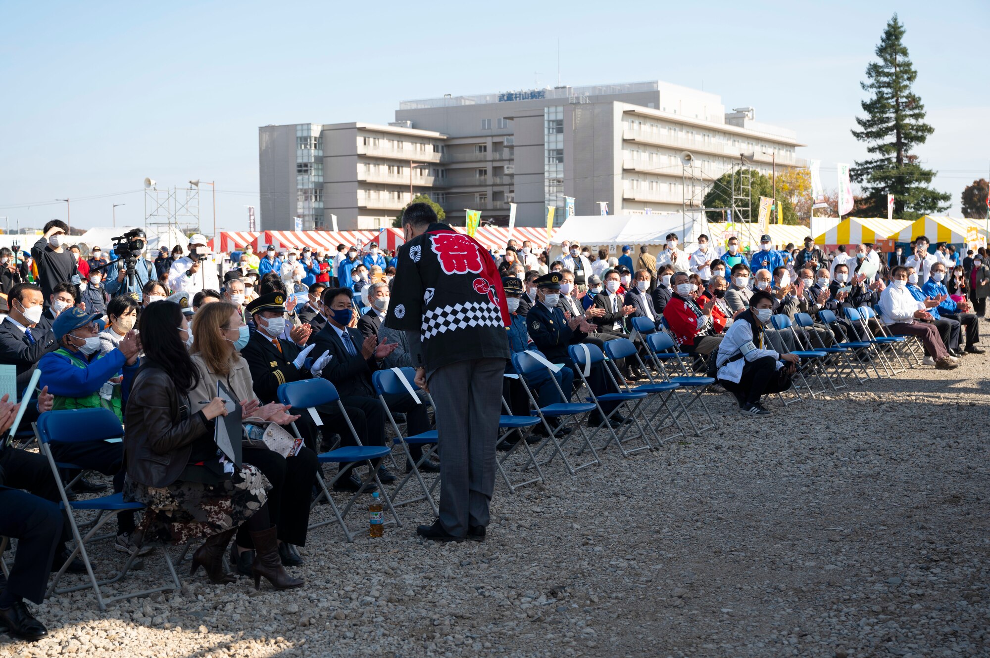 A man bows to a crowd of festival attendees