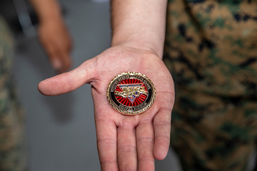U.S. Marine holds the 100th Anniversary coin in hand to celebrate the Marine Corps Air Facility (MCAF)  100th Anniversary Celebration at MCAF, Marine Corps Base Quantico, Va., Jun 13, 2019. The celebration recognizes the 100 years of support that MCAF has given the Marine Corps. (U.S. Marine Corps photo by Lance Cpl. Piper A. Ballantine)
