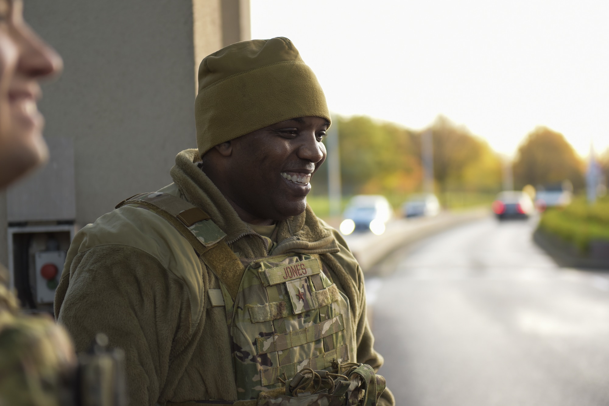 A man smiles while at a military gate