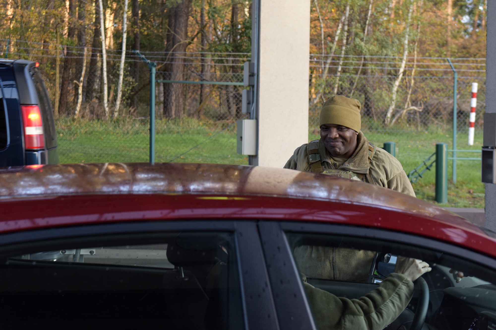 Man smiles to a person inside of a car