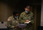 Soldiers of the 4th Sustainment Command (Expeditionary), deployed as Forward Assessment Sustainment Team 1 (FAST 1), in Albuquerque, New Mexico. FAST 1 executed a Joint Reception, Staging, Onward movement, and Integration (JRSOI) for Navy medical personnel deployed to support the Navajo Nation. FAST 1 Officer in Charge Maj. Arika Austin (left) speaks with Navy Capt.  Tony Nelipovich of Navy Emergency Preparedness Liaison Officer (NEPLO) - Arizona about the JRSOI process.
