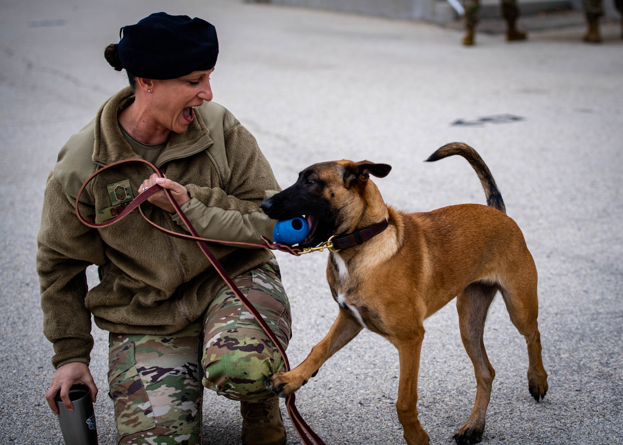 Woman plays with military working dog puppy