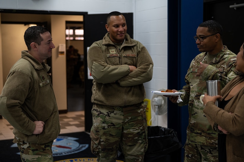 U.S. Air Force Capt. John Gillispie, 305th Air Mobility Wing True North chaplain, and Tech. Sgt. Carlos Catalan, 305th AMW True North religious affairs superintendent, speak with 305th AMW Airmen during a morale potluck at Joint Base McGuire-Dix-Lakehurst, N.J., Nov. 18, 2022.