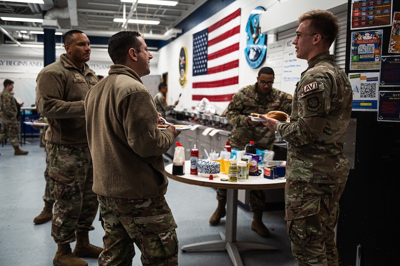 U.S. Air Force Capt. John Gillispie, 305th Air Mobility Wing True North chaplain, and Tech. Sgt. Carlos Catalan, 305th AMW True North religious affairs superintendent, speak with 305th AMW Airmen during a morale potluck at Joint Base McGuire-Dix-Lakehurst, N.J., Nov. 18, 2022.