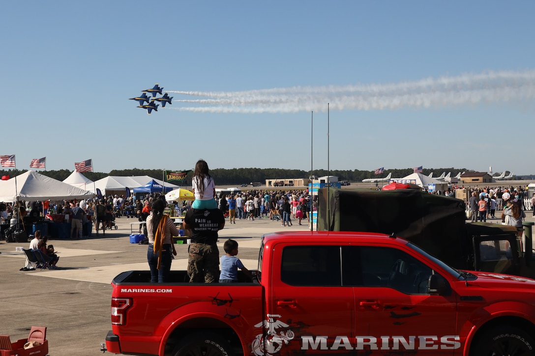 U.S. Marine Corps Staff Sgt. Faustino Cabrera, the Recruiting Substation Jacksonville Beach station commander, observes the the Navy Flight Demonstration Squadron, the Blue Angels, with his family at the Naval Air Station in Jacksonville, Florida, Oct. 22, 2022. Cabrera assisted the 6th Marine Corps District Enhanced Marketing Vehicle Team during the annual air show in support of recruitment efforts. (U.S. Marine Corps photo by Lance Cpl. Jareka Curtis)