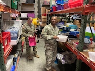 two men wearing u s army uniforms carry boxes of toys