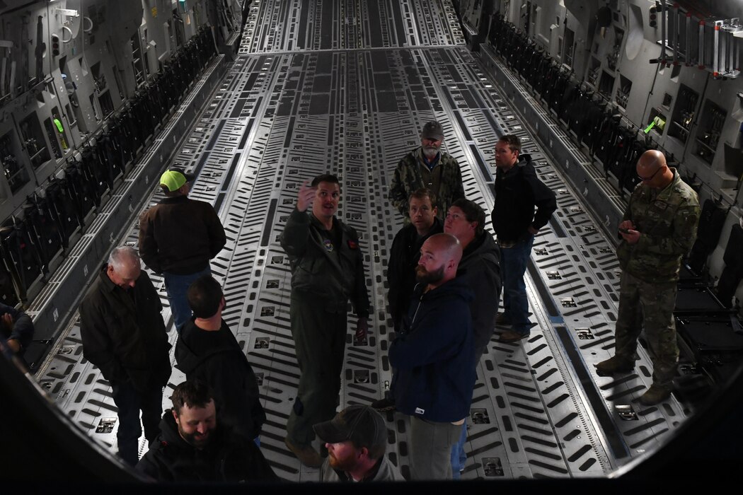 Master Sgt. Christopher Bernard, 97th Airlift Squadron support superintendent, explains C-17 Globemaster III capabilities to local farmers during Farm City Week at Altus Air Force Base, Oklahoma, Nov. 14, 2022. The C-17 is capable of rapid strategic deliveries of troops and all types of cargo and can hold more than 170,000 pounds. (U.S. Air Force photo by Airman 1st Class Miyah Gray)