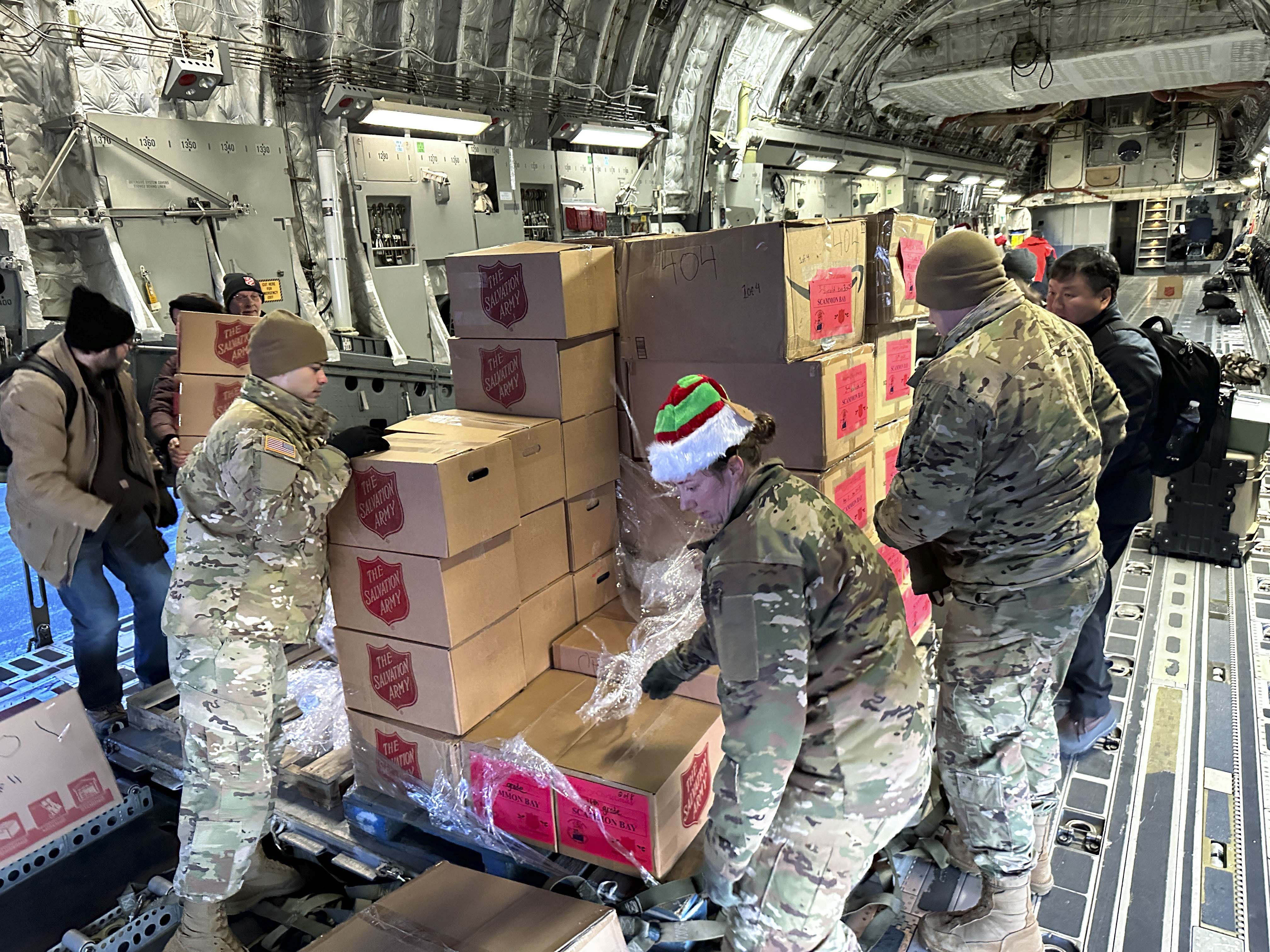 Soldiers load up a plan with boxs full of supplies and gifts from the Salvation Army