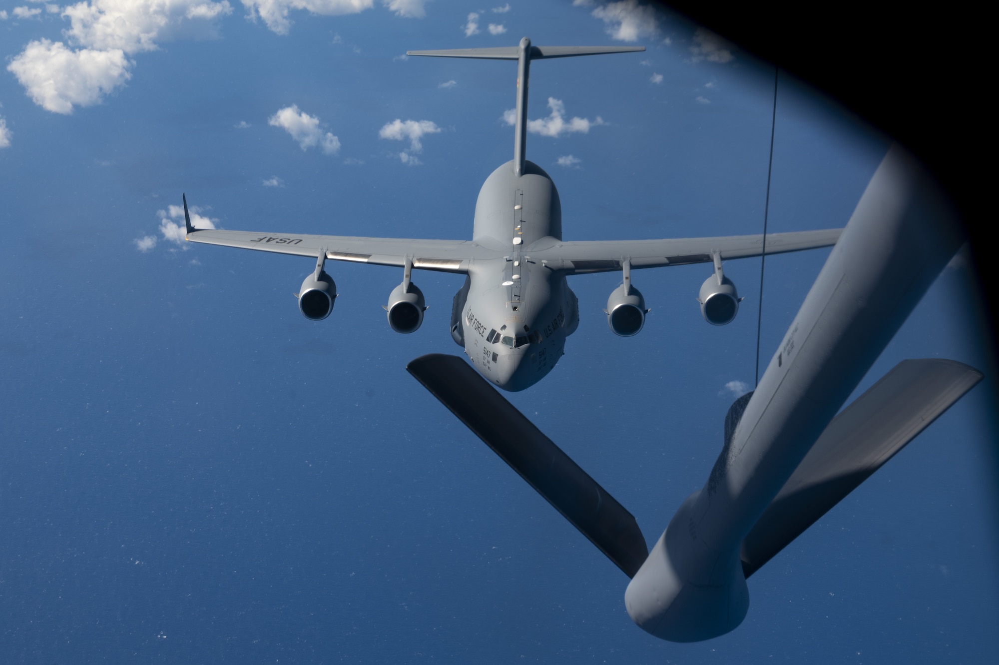 A U.S. Air Force C-17 Globemaster III  aircraft is refueled by a KC-135 Stratotanker aircraft from Fairchild Air Force Base, Washington, over the Pacific Ocean, Nov. 21, 2022. The completion of this cargo mission enabled Team Fairchild to improve the skills and knowledge of its crews, and ensure they can continue sustain rapid global mobility as the Air Force’s premier air refueling wing. (U.S. Air Force photo by Staff Sgt. Lawrence Sena)