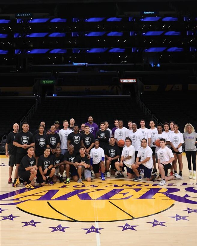 Guardians and Airmen pose for a group photo on the LA Lakers basketball court in the Crypto.com Arena.
