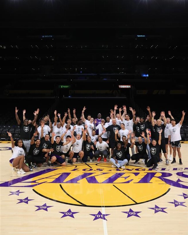 Guardians and Airmen pose for a group photo on the LA Lakers basketball court in the Crypto.com Arena.