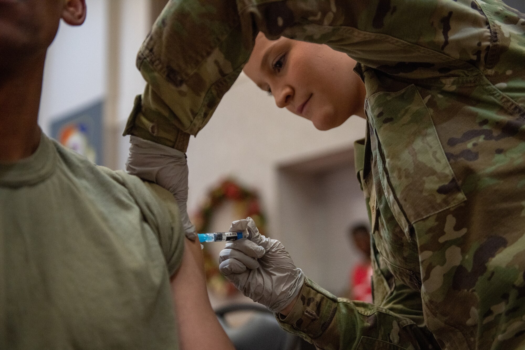 Senior Airman Sarah Mize, 22nd Medical Group aerospace medical technician, administers an influenza vaccine to a patient at a Flu Shot Point of Dispensing (POD) Oct. 18 2022, at McConnell Air Force Base, Kansas. PODs can be used for immunizations or dispensing medication quickly and efficiently in case of an emergency. (U.S. Air Force photo by Staff Sgt. Adam Goodly)