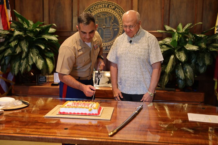 U.S. Marine Corps Col Speros Koumparakis, commanding officer, Marine Corps Base Hawaii, meets with Mayor Rick Blangiardi, mayor of Honolulu, to cut a birthday cake at City Hall in Honolulu, Hawaii, Nov. 16, 2022. The purpose of the visit was to share the tradition of cutting a cake in honor of the 247th birthday of the Marine Corps with the Mayor and city officials of Honolulu. (U.S. Marine Corps photo by Chief Warrant Officer 2 William Faffler)
