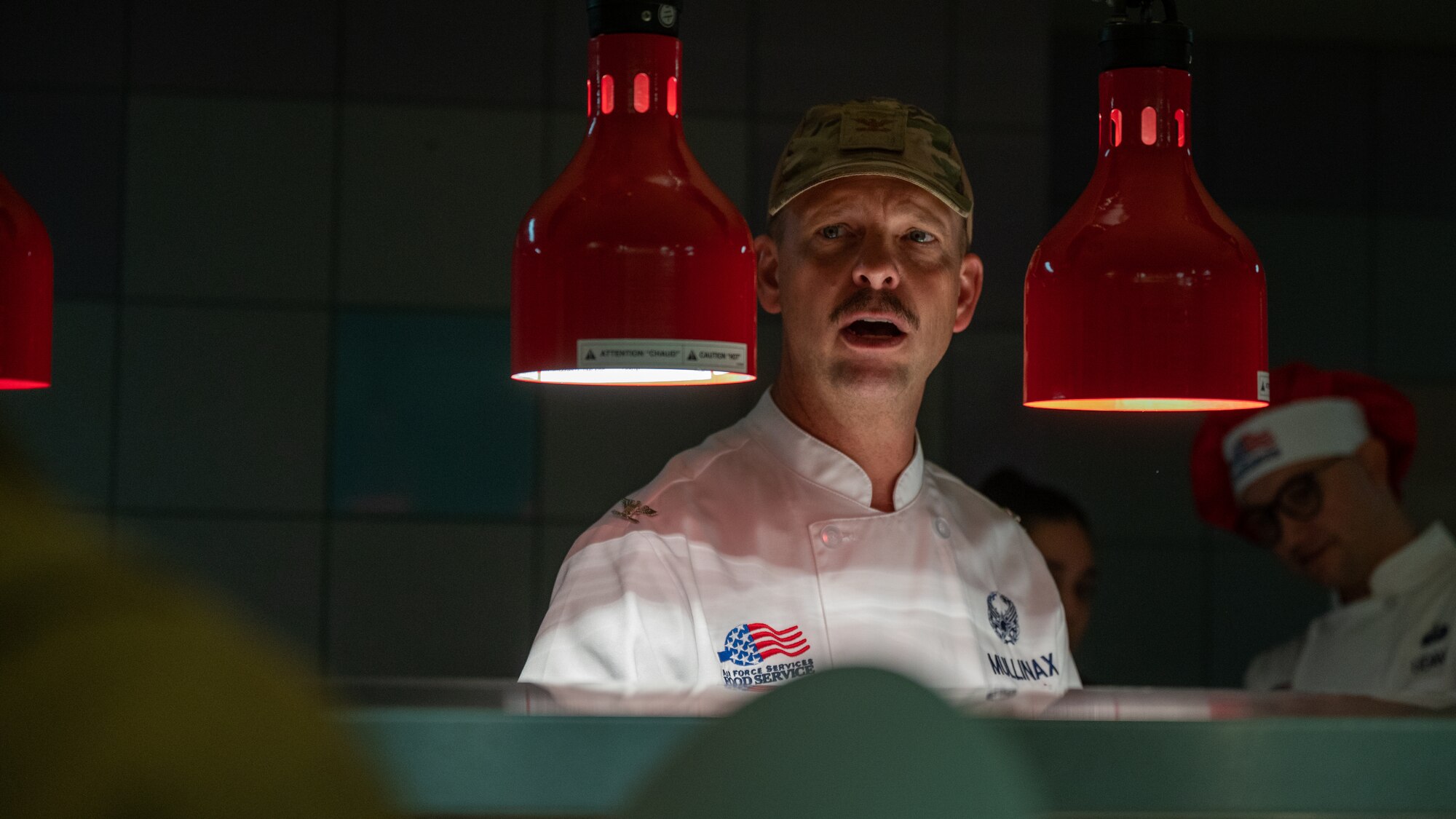 U.S. Air Force Col. Anthony Mullinax, 56th Mission Support Group commander, speaks with Airmen while serving food.