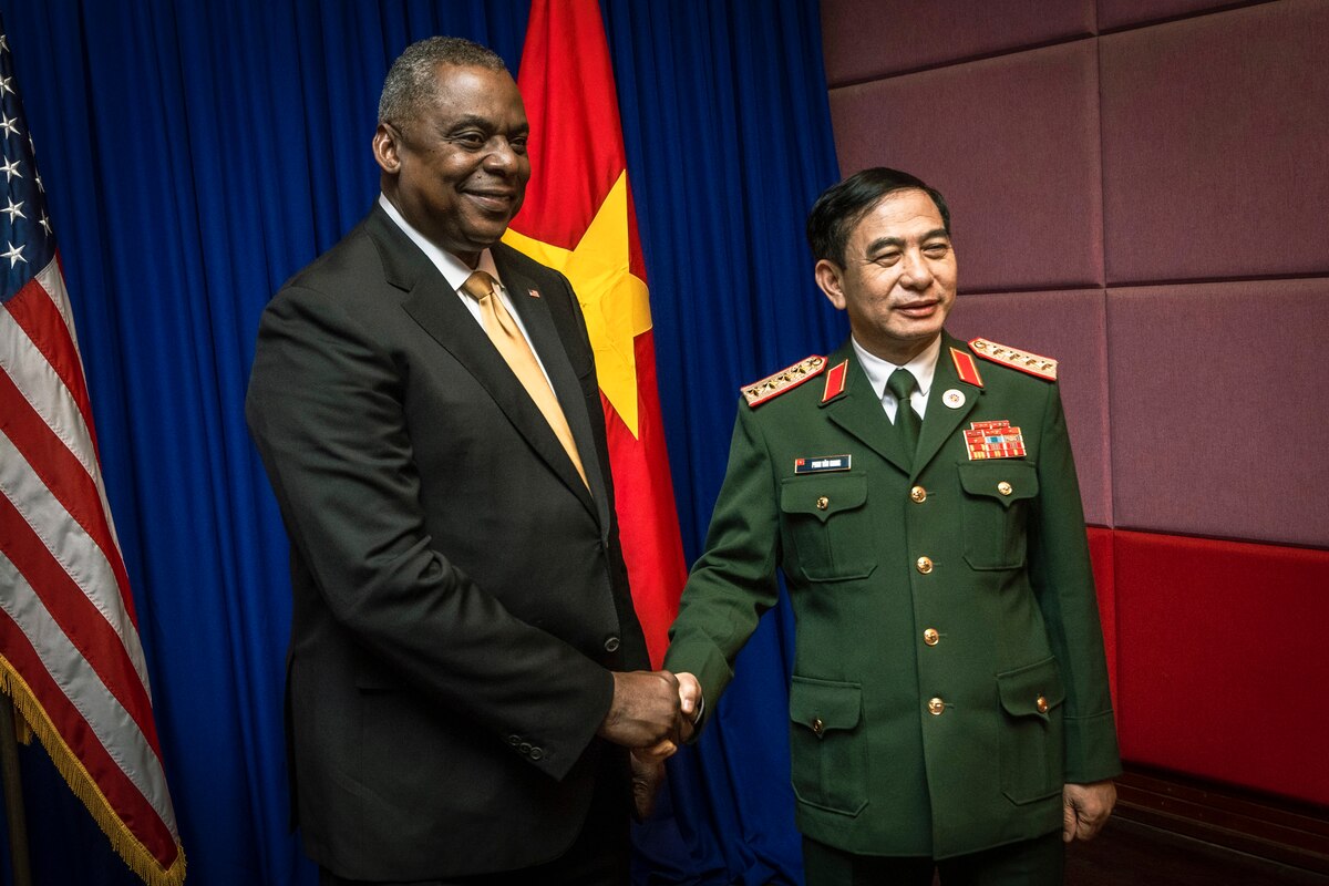 Two men shake hands.