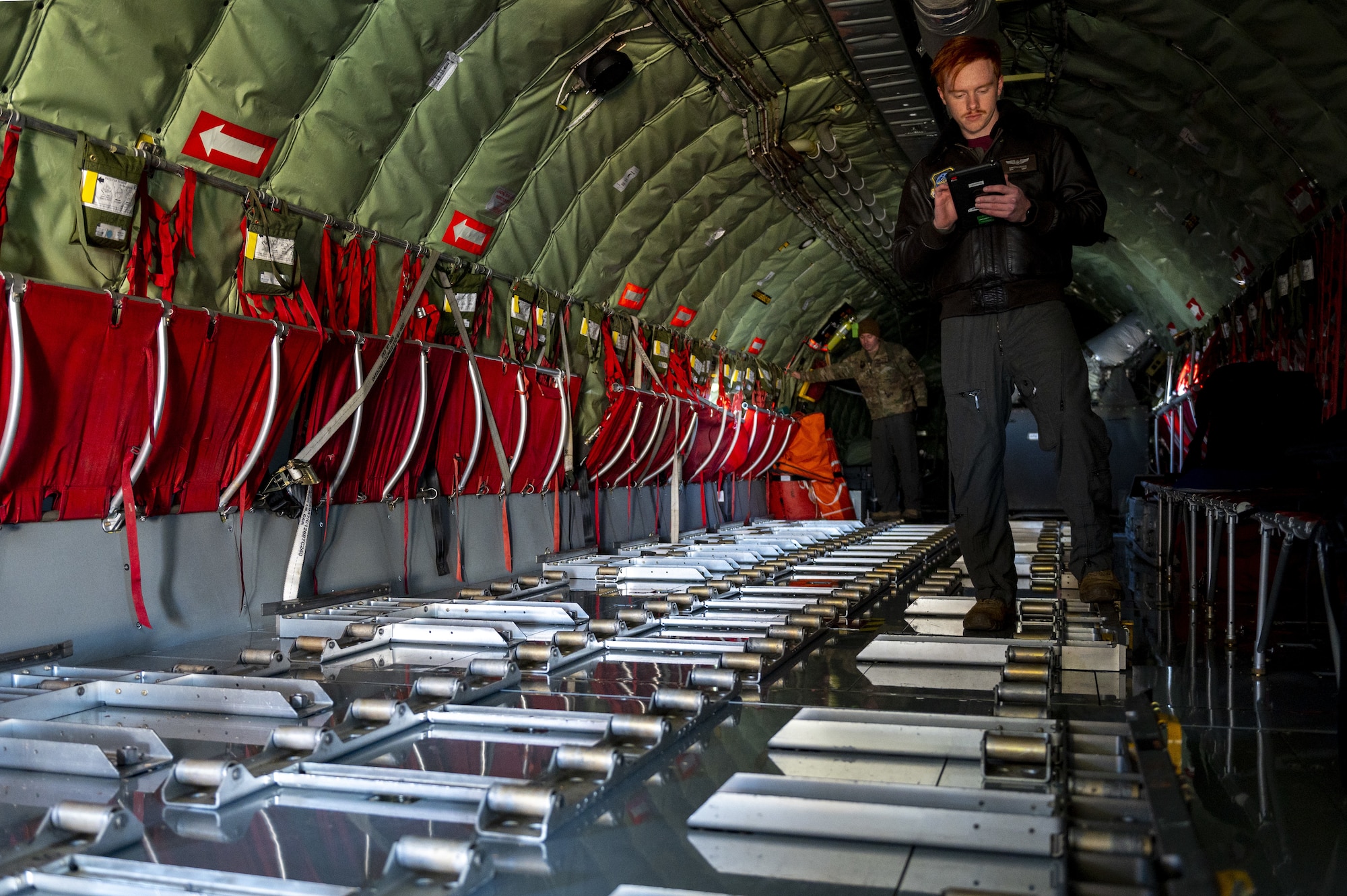 U.S. Air Force Senior Airman Dakota Griffis, 384th Air Refueling Squadron in-flight refueling specialist, inspects cargo rollers prior to takeoff from Fairchild Air Force Base, Washington, Nov. 18, 2022. Depending on fuel storage configuration, the KC-135 Stratotanker aircraft can carry up to 83,000 pounds of cargo, which is loaded, unloaded and monitored by in-flight refueling specialists. (U.S. Air Force photo by Staff Sgt. Lawrence Sena)