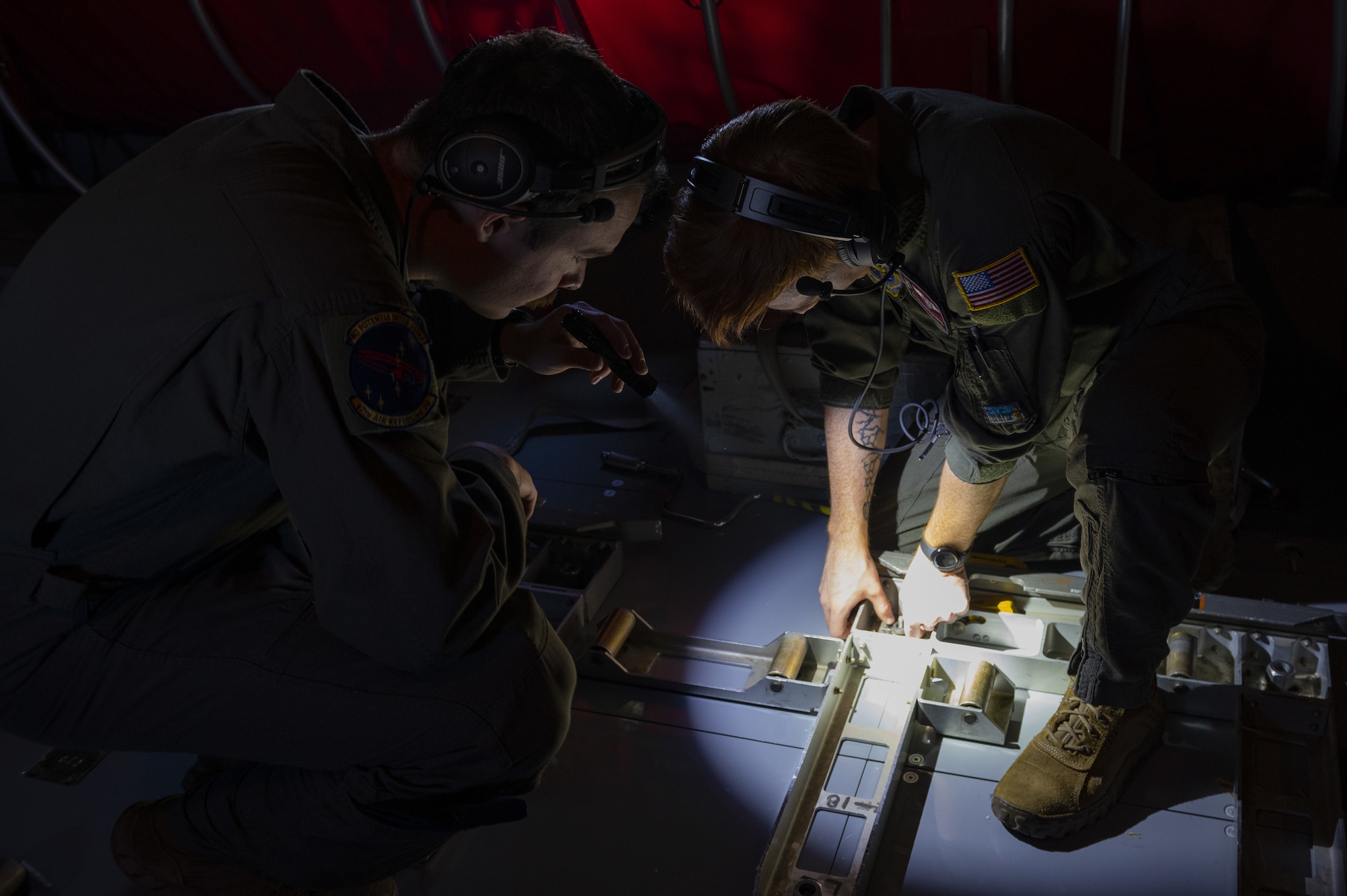 U.S. Air Force Senior Airman Matthew Ronnfeldt (left), 97th Air Refueling Squadron in-flight refueling specialist, and Senior Airman Dakota Griffis (right), 384th ARS in-flight refueling specialist, inspect cargo rollers prior to takeoff from Fairchild Air Force Base, Washington, Nov. 18, 2022. Depending on fuel storage configuration, the KC-135 Stratotanker aircraft can carry up to 83,000 pounds of cargo, which is loaded, unloaded and monitored by in-flight refueling specialists. (U.S. Air Force photo by Staff Sgt. Lawrence Sena)