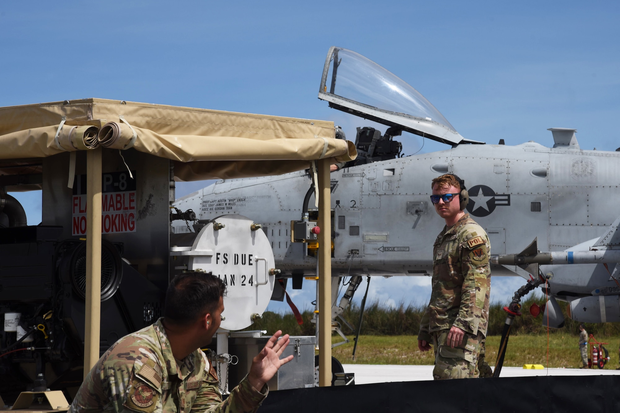 Photo of two Airmen talking on a flight line