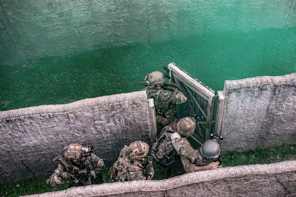 Army Green Berets conduct clearing procedures while evacuating a simulated casualty during the Joint Pacific Multinational Readiness Center rotation training exercise at Schofield Barracks, Hawaii, Nov. 7, 2022. The exercise is designed to build combat readiness.