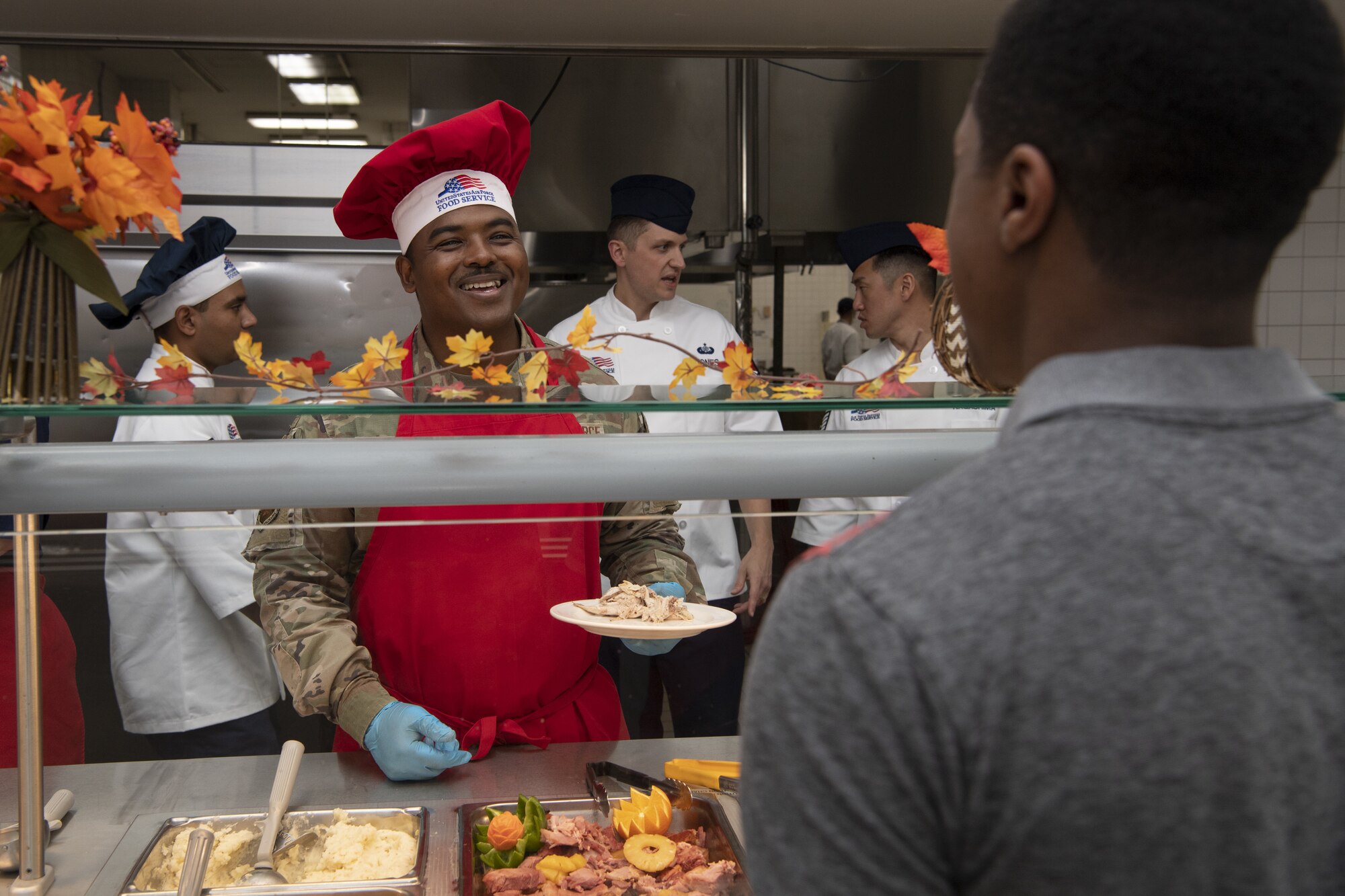 Chief Master Sgt. Jerry Dunn, 374th Airlift Wing command chief, serves Thanksgiving meals to service members and families at the Samurai Café Dining Facility at Yokota Air Base, Japan, Nov. 24, 2022. U.S. Ambassador to Japan Rahm Emanuel, U.S. Air Force Lt. Gen. Ricky Rupp, Commander of U.S. Forces Japan and Fifth Air Force, and 374th Airlift Wing leadership took time to serve and celebrate Thanksgiving Day alongside service members and families assigned to Yokota. (U.S. Air Force photo by Tech. Sgt. Christopher Hubenthal)