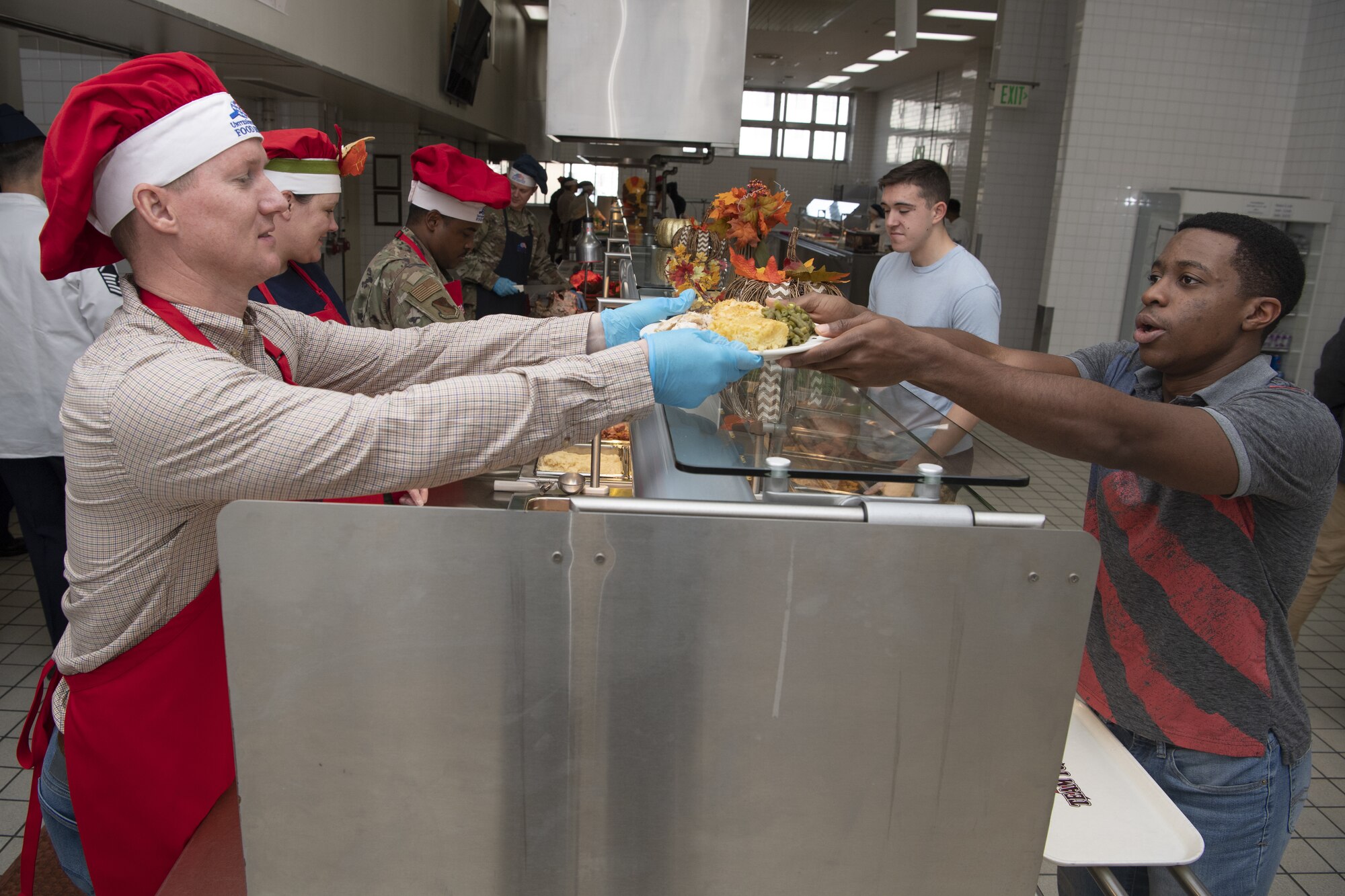 Maj. Ryan Abel, 374th Comptroller Squadron commander, serves Thanksgiving meals to service members and families at the Samurai Café Dining Facility at Yokota Air Base, Japan, Nov. 24, 2022. U.S. Ambassador to Japan Rahm Emanuel, U.S. Air Force Lt. Gen. Ricky Rupp, Commander of U.S. Forces Japan and Fifth Air Force, and 374th Airlift Wing leadership took time to serve and celebrate Thanksgiving Day alongside service members and families assigned to Yokota. (U.S. Air Force photo by Tech. Sgt. Christopher Hubenthal)