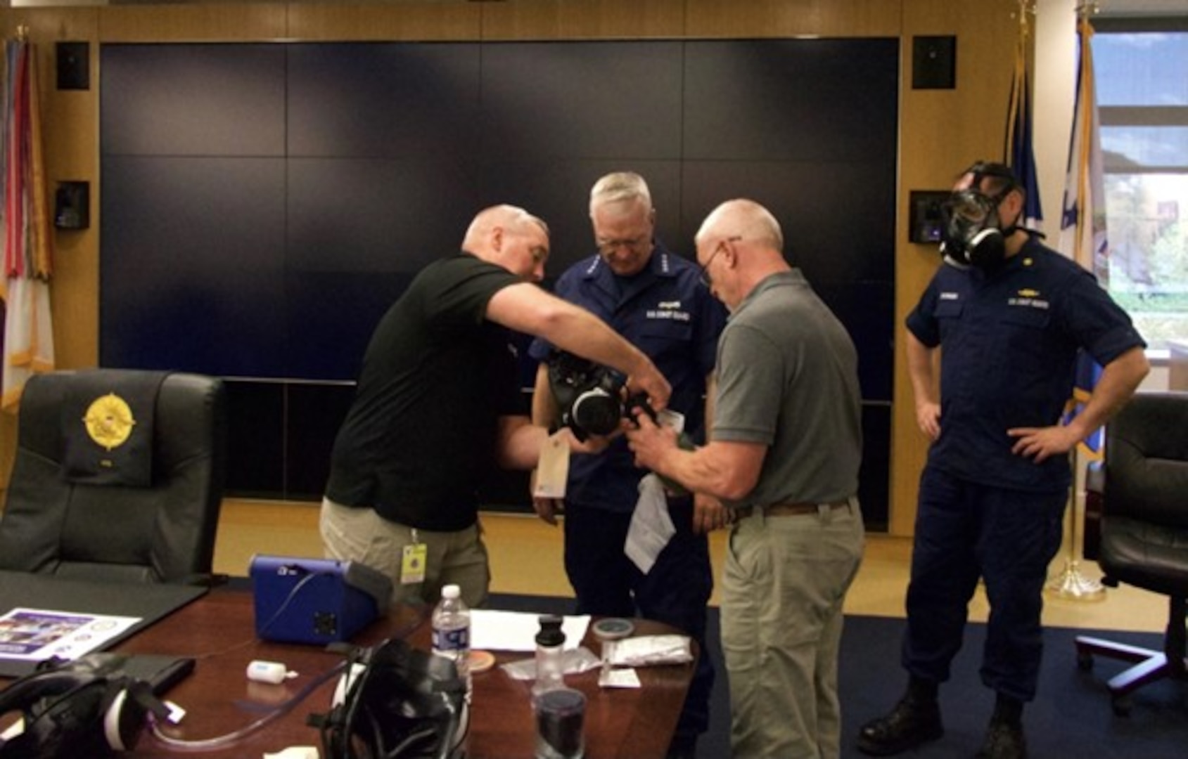Vice Commandant Adm. Steve Poulin (center) gets fitted for a M-50 mask during a Chemical, Biological, Radiological, and Nuclear (CBRN) training session at Coast Guard Headquarters in September 2022. Poulin took part to remind CBRN-equipped units to complete required training to enhance readiness. (U.S. Coast Guard photo)