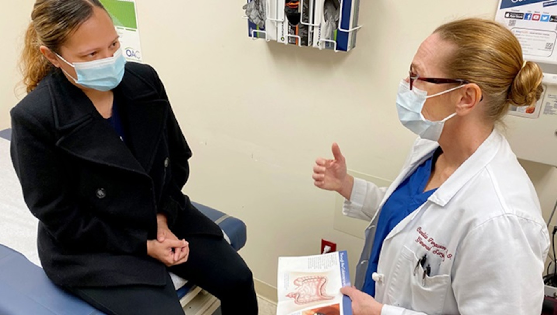 U.S. Navy Cmdr. Candida Ferguson, a general surgeon at Naval Hospital Jacksonville, talks with a patient about colorectal cancer screening. The Defense Health Agency established new age recommendations for screenings. Regular screening with a stool test, sigmoidoscopy, or colonoscopy, beginning at age 45, is the key to preventing colorectal cancer and finding it early.