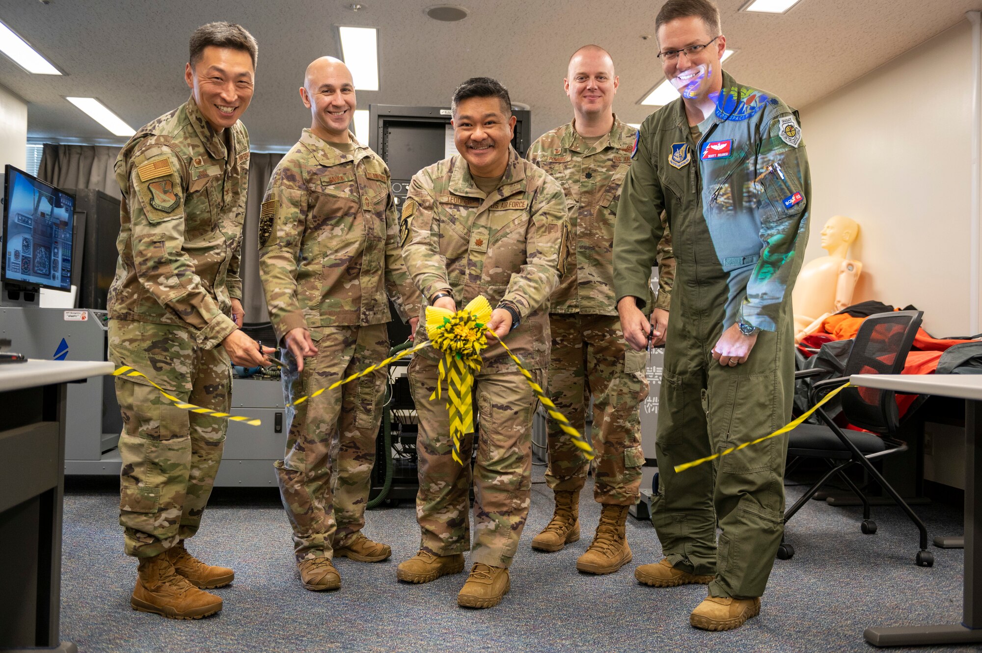 Five soldiers hold up a ribbon during a ceremony.