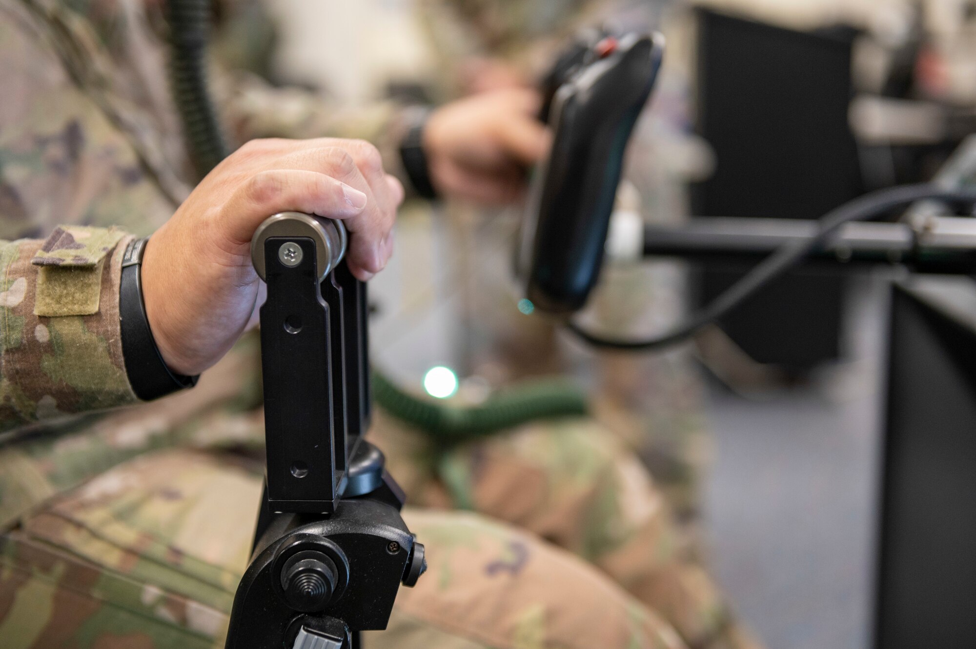 Close up view, right side, of a man griping flight controls of a video game