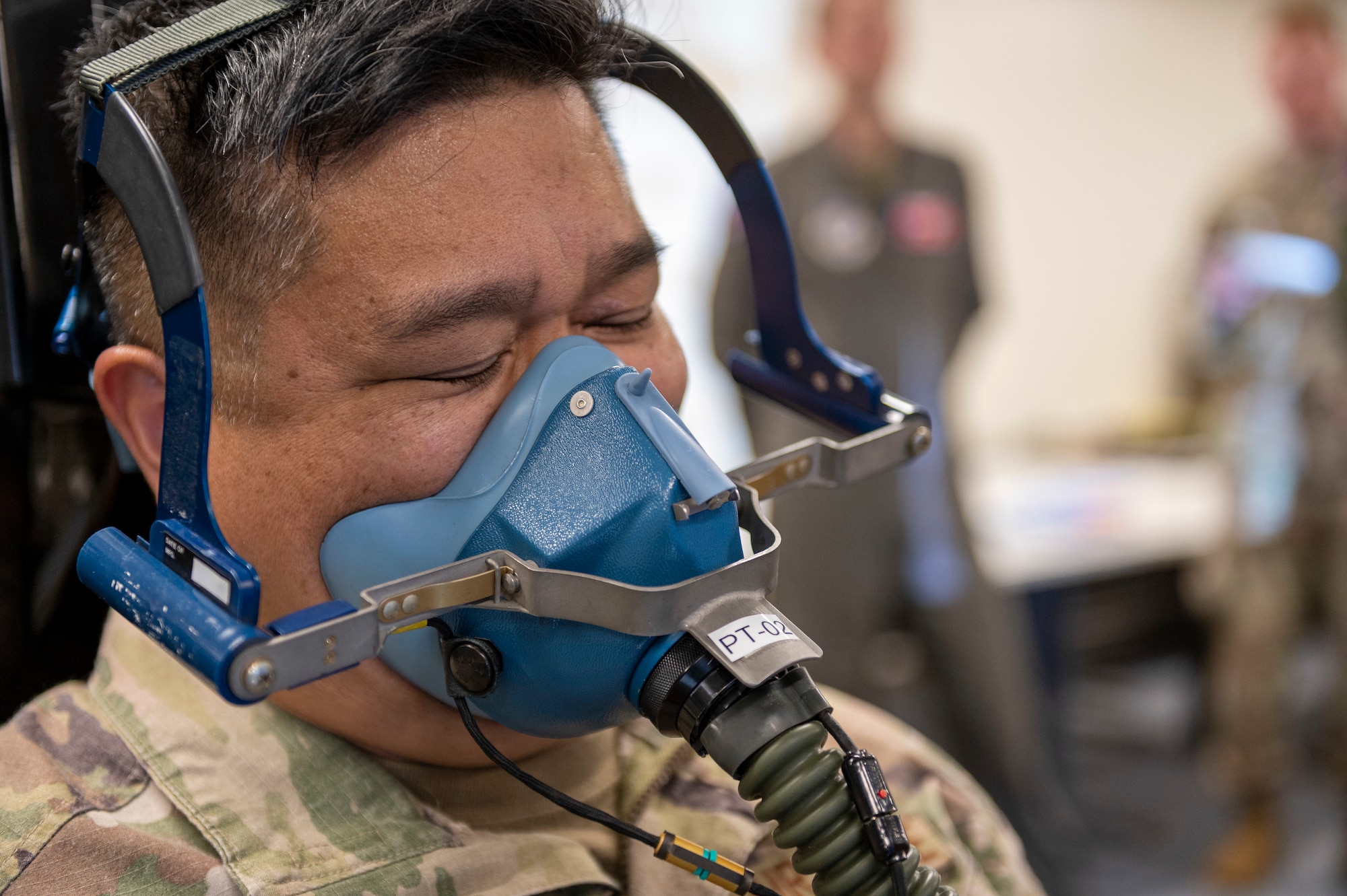 Close up of a soldier's face, wearing a breathing mask, struggling to keep his eyes open.