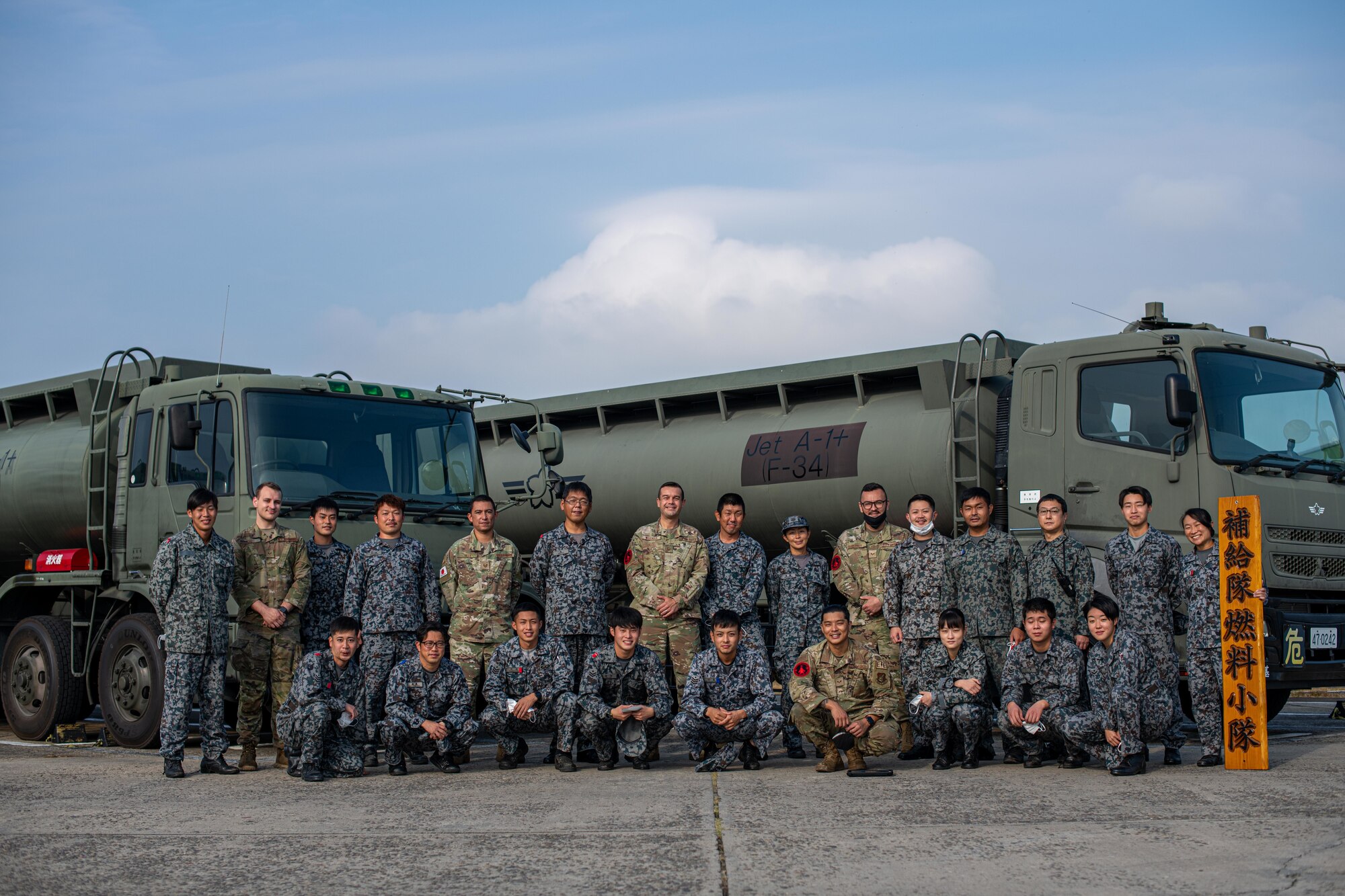 Airmen and Japanese military pose for a photo.