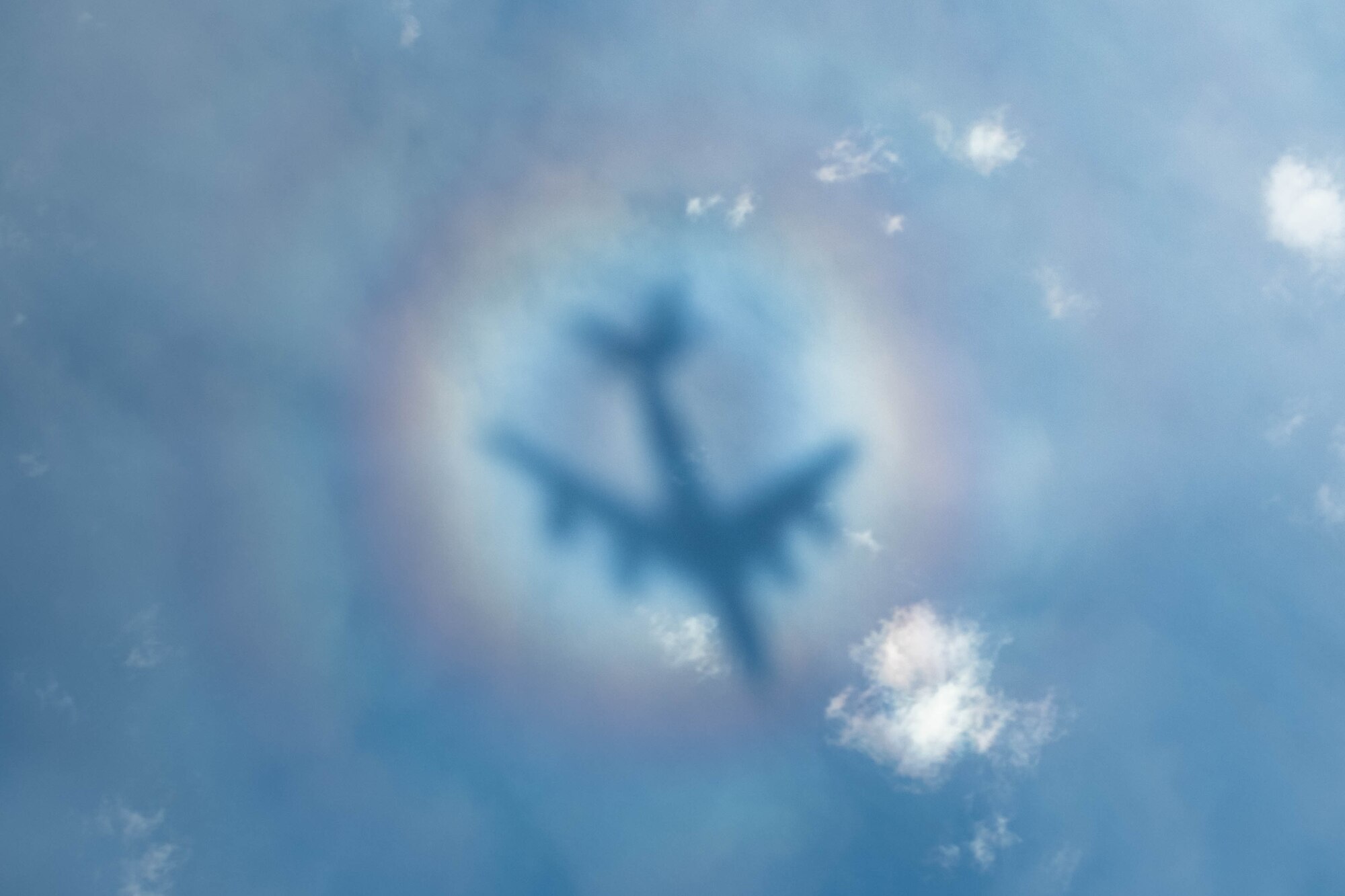 A jet casts a shadow over the ocean.