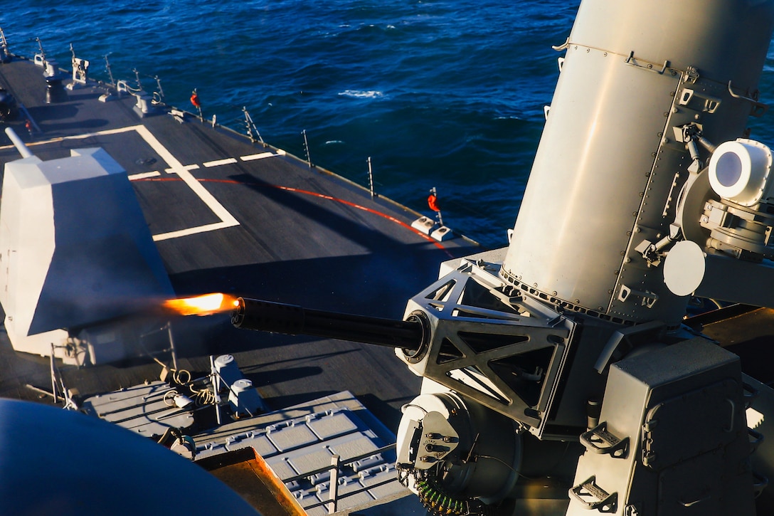 A flame comes out of a close-in weapons system on the USS Paul Ignatius.