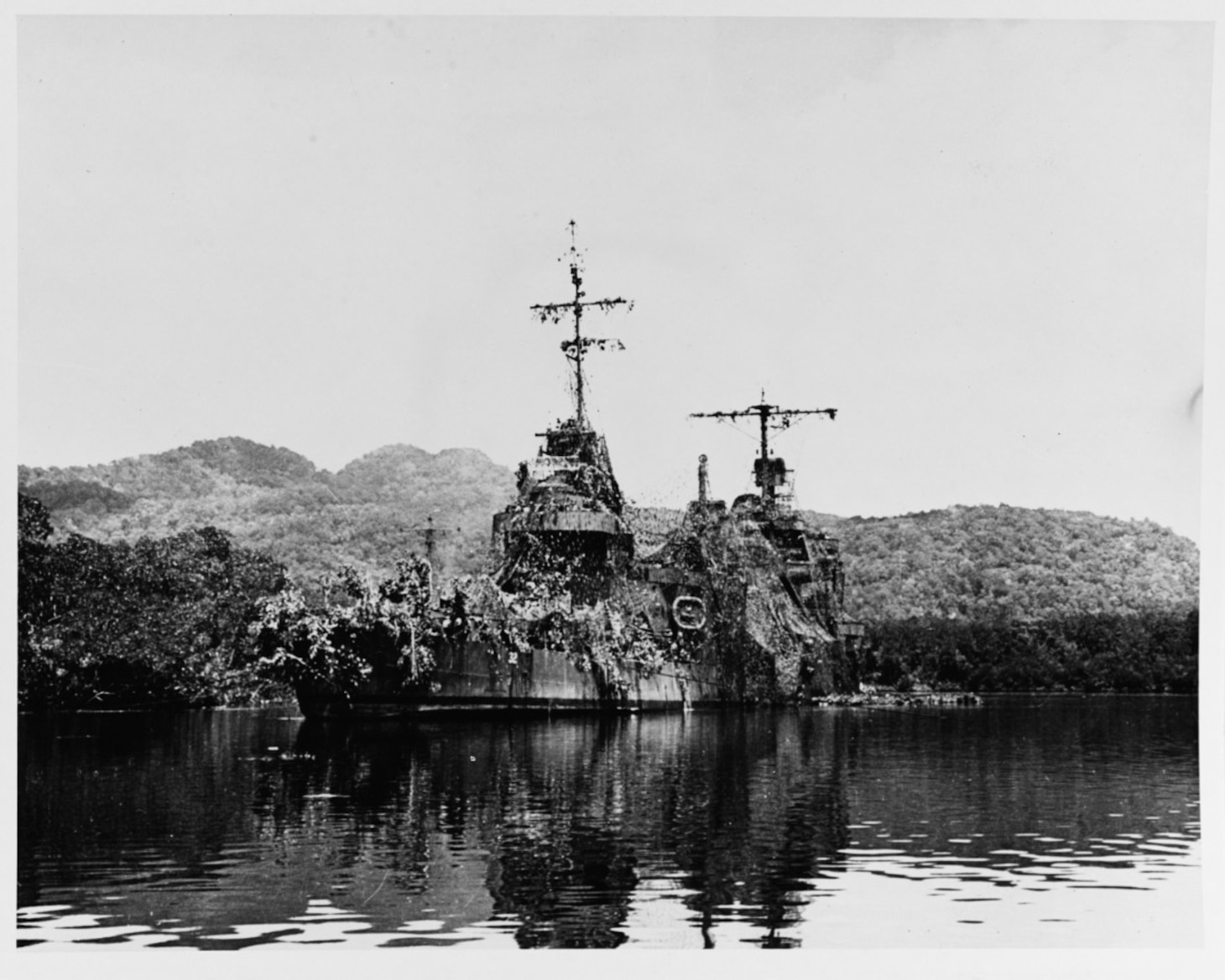 USS New Orleans (CA-32), ca. 1942. Camouflaged at Tulagi, Solomon Islands, some days after she was torpedoed during the Battle of Tassafaronga on 30 November 1942. Note that her stern is riding high and that her forward end is low in the water. The torpedo and subsequent explosion had severed her bow between #1 and #2 eight-inch gun turrets. Official Navy Photograph, now in the collections of the U.S. National Archives. (80-G-216014)