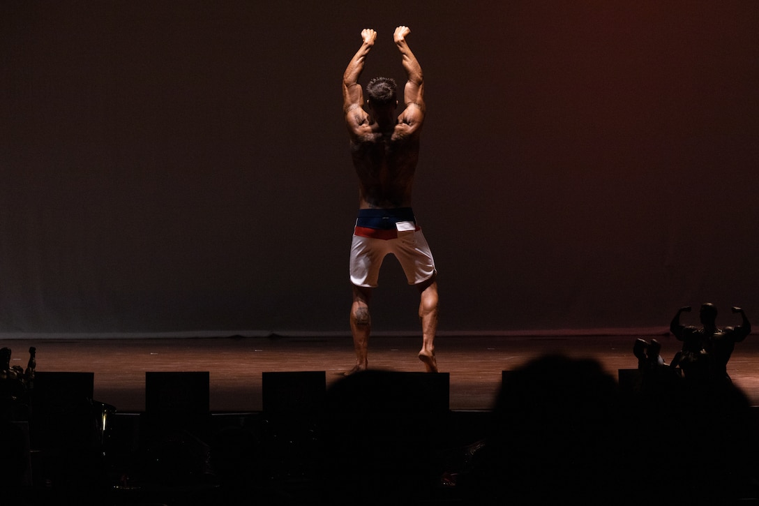 A U.S. Marine with the Camp Pendleton Varsity Bodybuilding team flexes his physique during a Camp Pendleton Varsity Bodybuilding team promotion event at the Pendleton Theater & Training Center on Marine Corps Base Camp Pendleton, California. The event consisted of competitors from different categories such as Classic Physique, Men’s Physique and Women’s Physique, showcasing their physiques for the audience. The participating Marines intended to raise awareness about the team and inspire other Marines to join them. (U.S. Marine Corps photo by Lance Cpl. Watts)