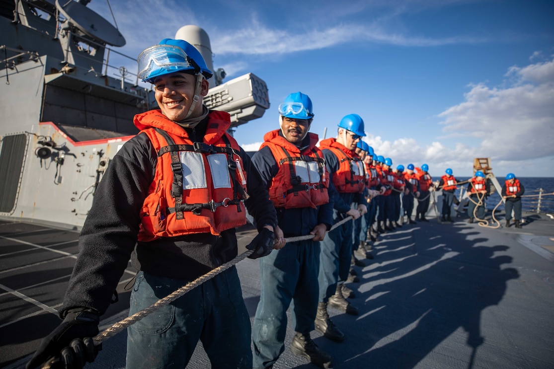 Sailors hold a line aboard the Arleigh Burke-class guided-missile destroyer USS Roosevelt (DDG 80) during a replenishment-at-sea with the fast combat support ship USNS Arctic (T-AOE 8), Nov. 22, 2022.