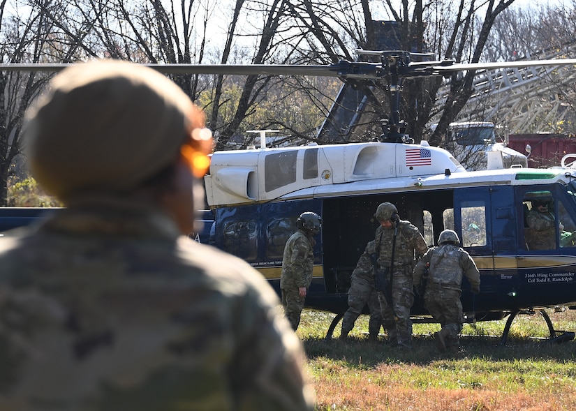 Airmen load a simulated victim into a UH-1N Huey during Tactical Combat Casualty Care training at Joint Base Andrews, Md., Nov. 18, 2022. The TCCC Training consisted of moving towards injured victims, then performing proper emergency care methods and evacuation by helicopter. (U.S. Air Force photo by Airman 1st Class Austin Pate)