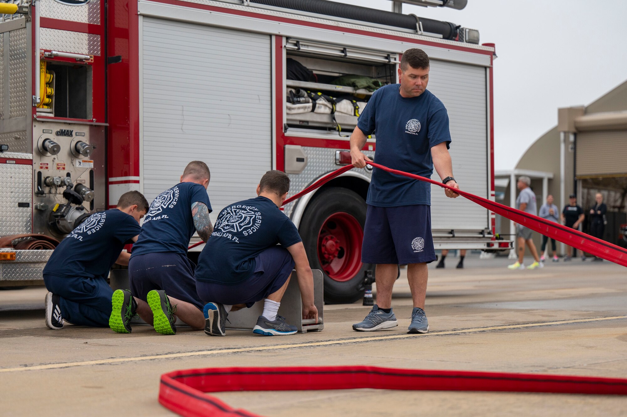 Airmen operate a fire hose