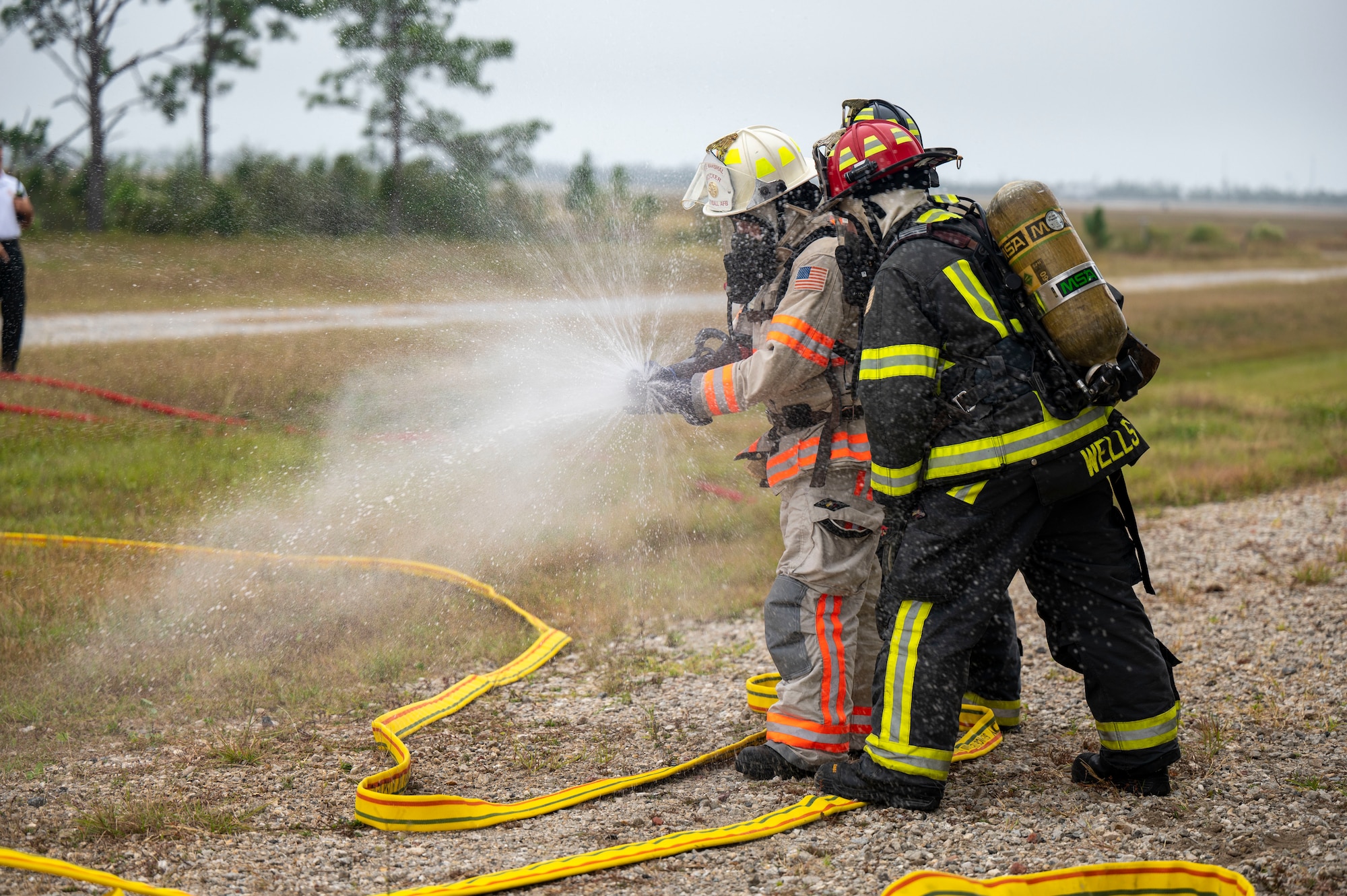 Firefighters operate a fire hose