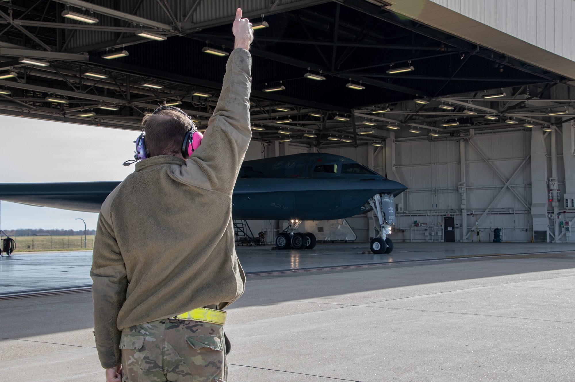 A 509th Bomb Wing maintainer marshals a B-2 Spirit stealth bomber before takeoff at Whiteman Air Force Base, Missouri, Nov. 7, 2022. Maintainers participate in exercises to keep the B-2 ready to fly anytime, anywhere. (U.S. Air National Guard photo by Airman 1st Class Phoenix Lietch)