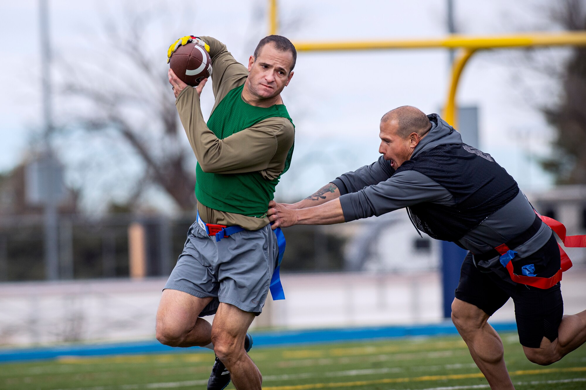 Man catches football while being pushed by opposing player