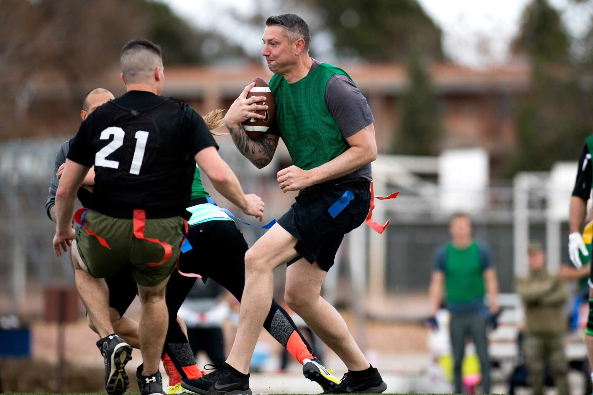 Man with football blocks two men