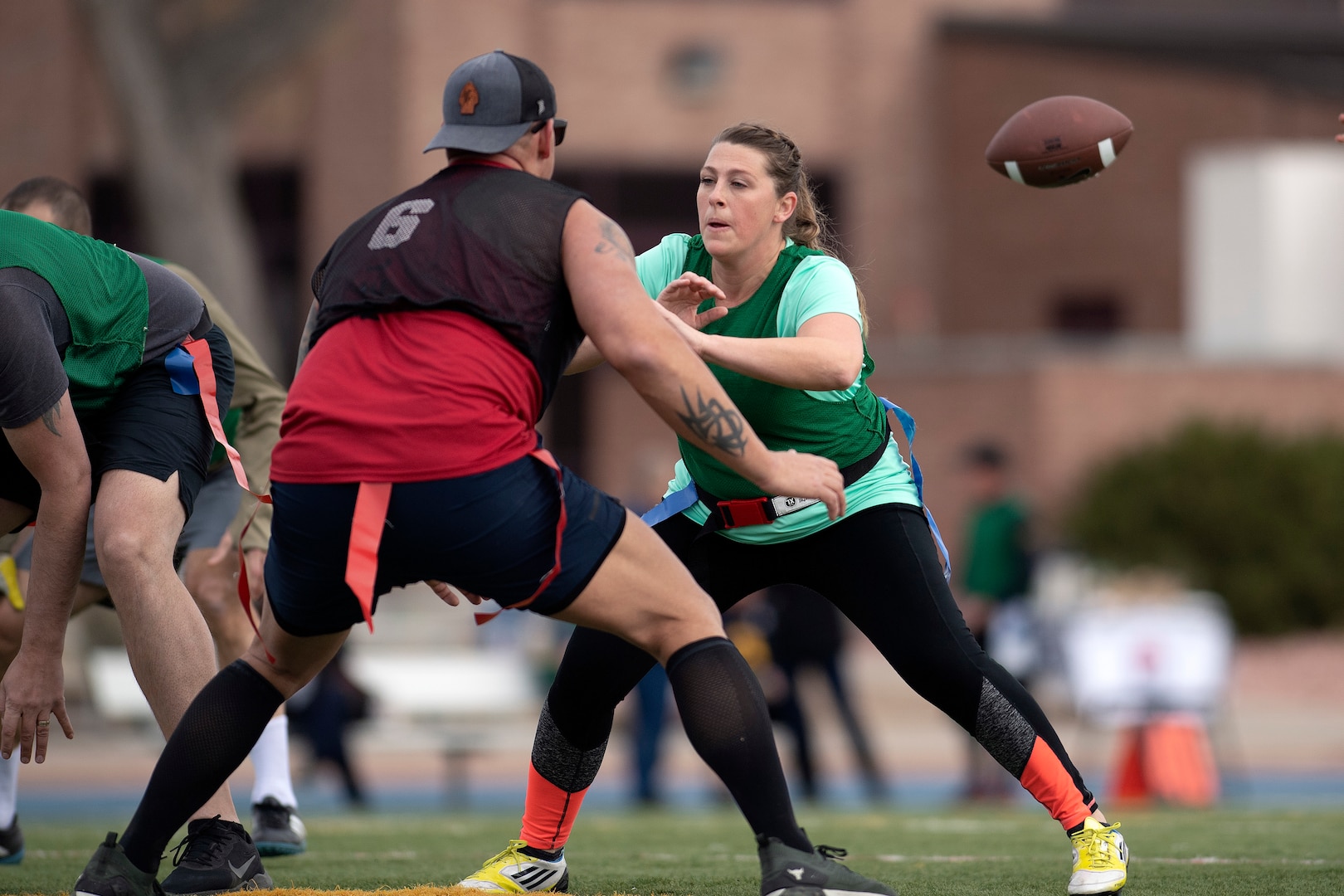 Woman guards man as football flies past