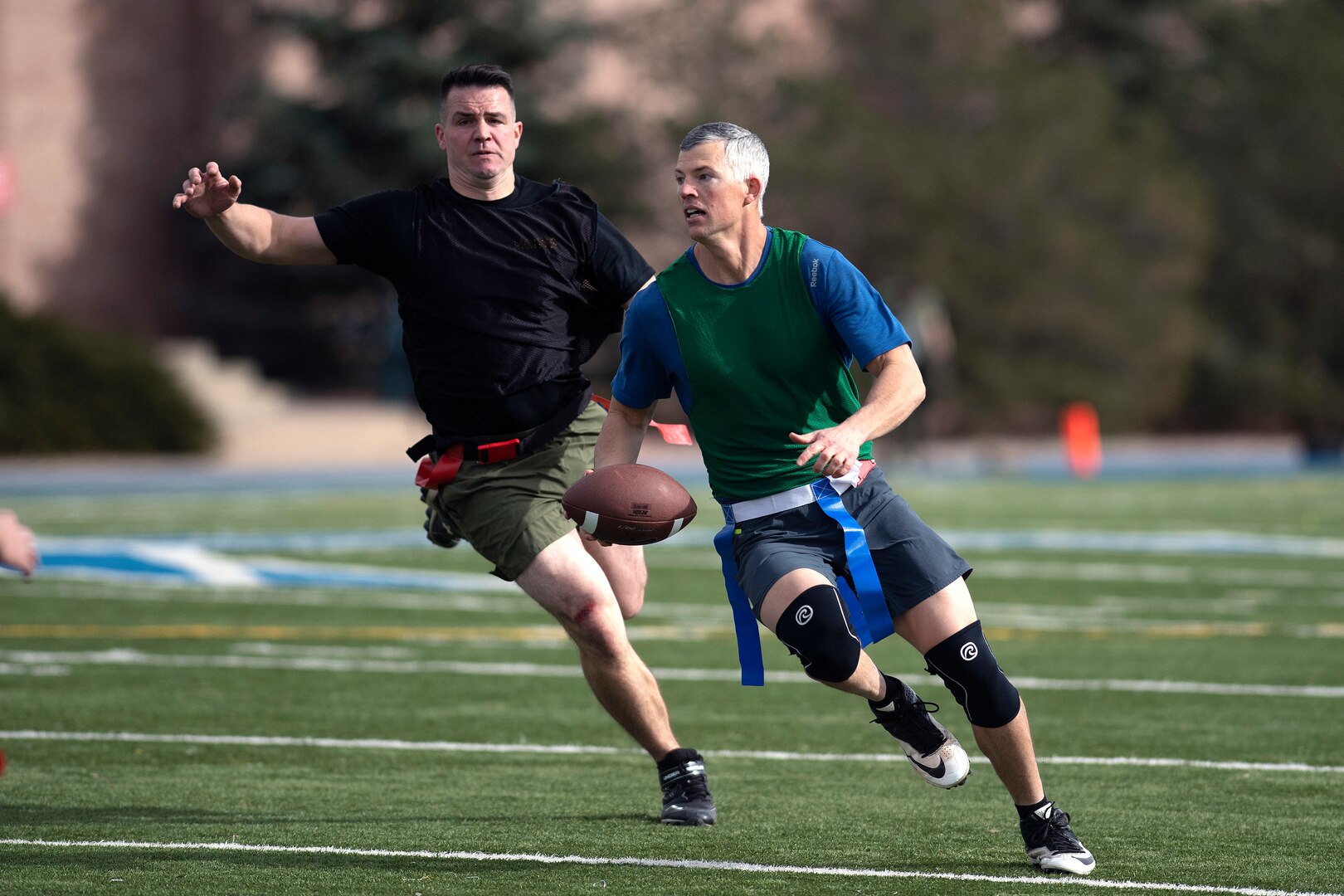 Man chases another man with football