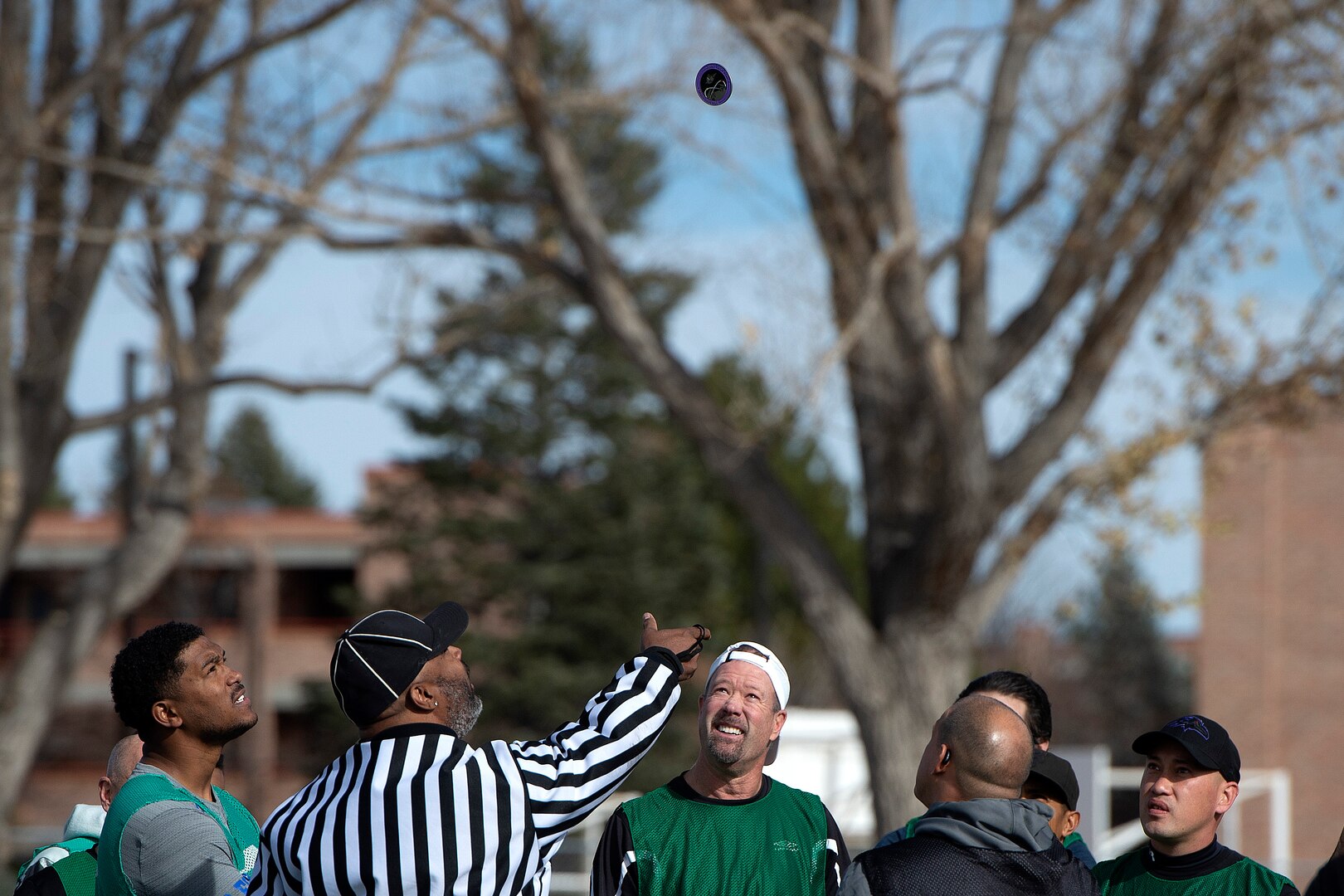 Referee tosses coin as people watch