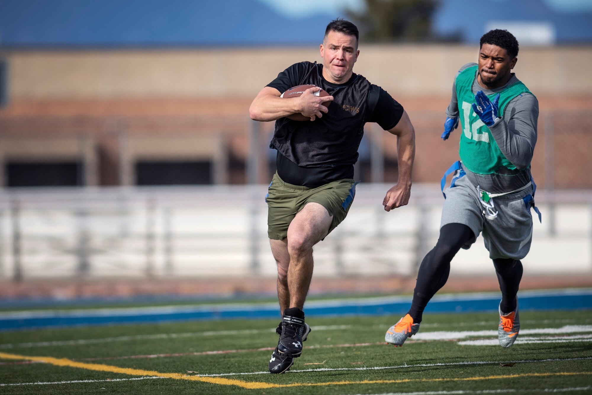 Man chasing another man with football