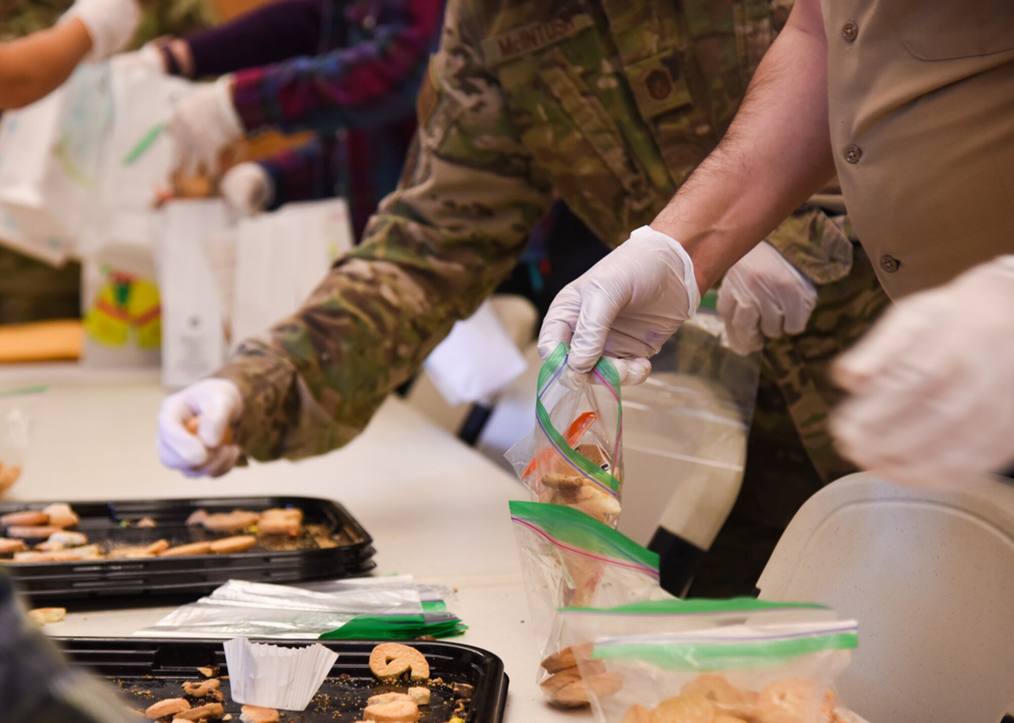 Goodfellow members prepare bags of cookies during the Cookie Caper, Dec. 7, 2021, on Goodfellow Air Force Base, Texas. Donations were accumulated at the Chamber of Commerce and at the Community Learning Center on base. (U.S. Air Force photo by Staff Sgt. Tyrell Hall)