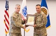 Lt. Col. Trond Ruud and Col. Scott Madore pose with the Product Manager Small Arms Fire Control (PdM SAFC) organizational charter during an assumption of charter ceremony that established PdM SAFC on Fort Belvoir, August 12. The establishment of the product management office concludes phase three of Program Executive Office (PEO) Soldier’s reorganization efforts, following the disestablishment of Project Manager, Soldier Maneuver and Precision Targeting in July.