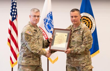 Lt. Col. Trond Ruud and Col. Scott Madore pose with the Product Manager Small Arms Fire Control (PdM SAFC) organizational charter during an assumption of charter ceremony that established PdM SAFC on Fort Belvoir, August 12. The establishment of the product management office concludes phase three of Program Executive Office (PEO) Soldier’s reorganization efforts, following the disestablishment of Project Manager, Soldier Maneuver and Precision Targeting in July.